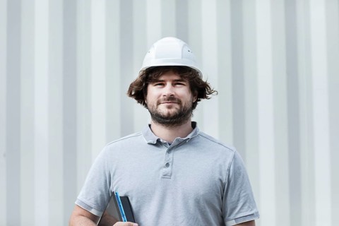 Technician with beard middle aged and working outside with polo shirt and helmet