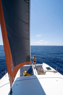 Young woman standing by the foresail