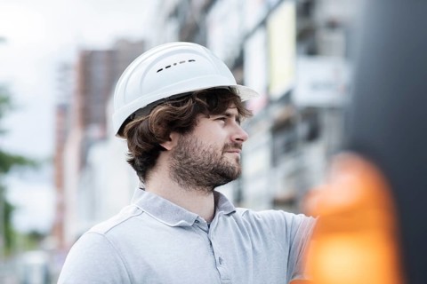 Technician with beard middle aged and working outside with polo shirt and helmet