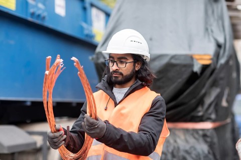 Technician with beard and helmet working in a recycling yard