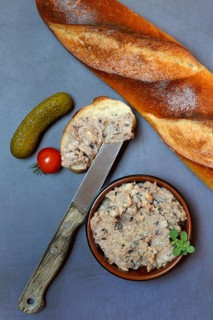 A bowl of meat terrine and slice of bread
