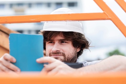 Technician with beard middle aged and working outside with polo shirt and helmet