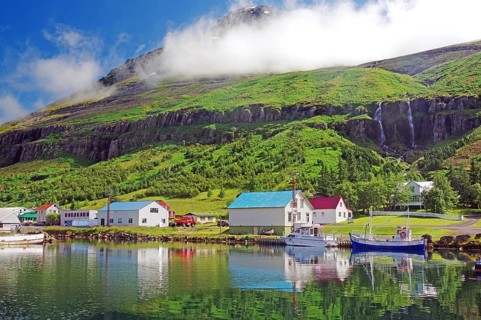 Boats and small houses reflected in the fjord
