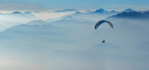 Paragliding with the peaks of the Garda Mountains and Bergamo Alps