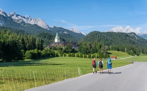 Three hikers in front of Elmau Castle