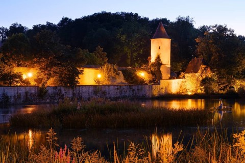 Illuminated town wall with septic tank and park keeper's house at the town pond