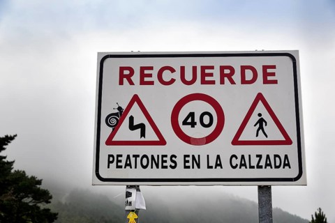 Sign with various traffic signs warning pedestrians on the road