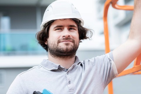 Technician with beard middle aged and working outside with polo shirt and helmet