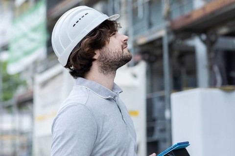 Technician with beard middle aged and working outside with polo shirt and helmet