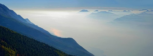 Lake Garda in the morning mist with Lake Garda mountains and Bergamo Alps