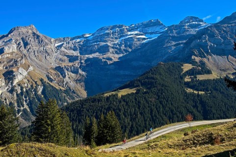 Cyclists in front of the mountain range Les Diablerets near the village Les Diablerets