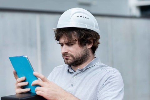 Technician with beard middle aged and working outside with polo shirt and helmet