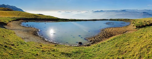 Small lake with the peaks of the Garda Mountains and Bergamo Alps