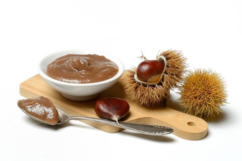 Chestnut cream in bowl on wooden board