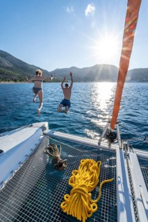 Young woman and young man jumping into the water