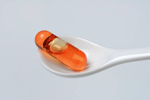 Capsule with omega-3 fatty acids in spoon