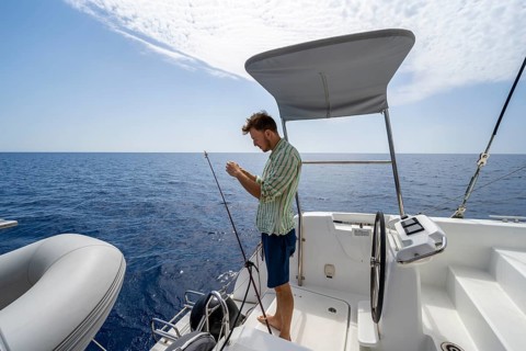 Young man fishing on a boat