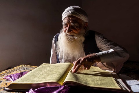 Sufi priest studying the holy Quran in the Shrine of Mawlana Abdur Rahman Jami