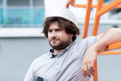 Technician with beard middle aged and working outside with polo shirt and helmet