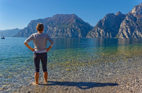 Hiker with footbath to cool down in Lake Garda