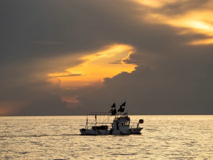 Fishing boat in front of dark clouds