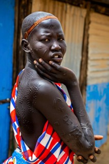 Girl with body scars from the Laarim tribe