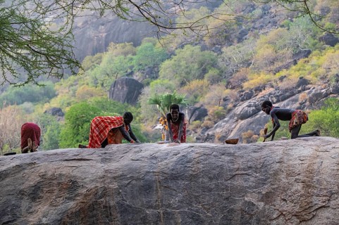 Young girls grinding Sorghum on a rock