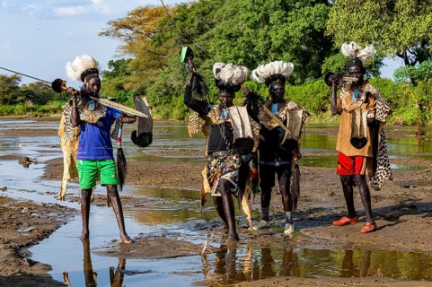 Men from the Toposa tribe posing in their traditional warrior costume