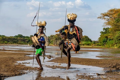 Men from the Toposa tribe posing in their traditional warrior costume