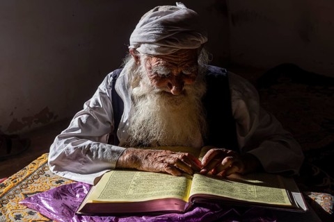 Sufi priest studying the holy Quran in the Shrine of Mawlana Abdur Rahman Jami