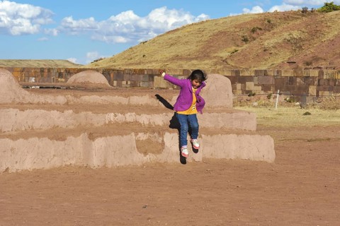 Little indigenous girl jumping from a platform