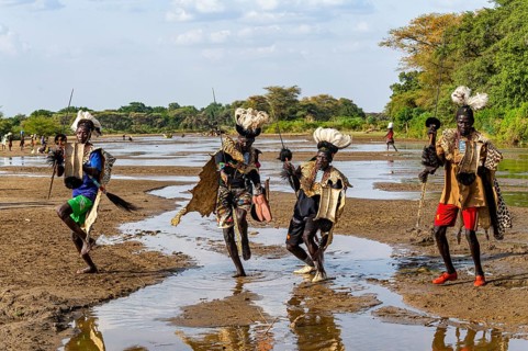 Men from the Toposa tribe posing in their traditional warrior costume