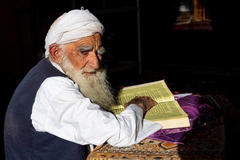 Sufi priest studying the holy Quran in the Shrine of Mawlana Abdur Rahman Jami