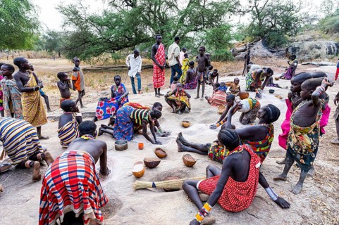Young girls grinding Sorghum on a rock