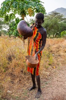 Laarim woman filtering Sorghum in a carabass