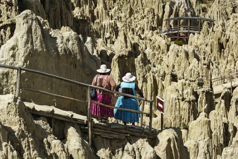 Indigenous woman in traditional dress admire the bizarre rock formations in the Valle de la Luna