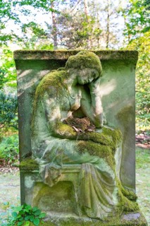 Grave sculpture with bird's nest in the lap