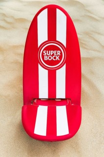 Red and white beach chair in the sand