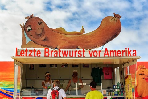 Customers at the food stall labelled Last Bratwurst in front of America