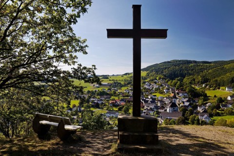 Cross of the Kreuzberg Chapel with a view of the Duedinghausen district of the town of Medebach