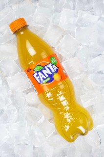 Fanta Orange lemonade soft drink beverage in a plastic bottle on ice cube ice cubes in Germany