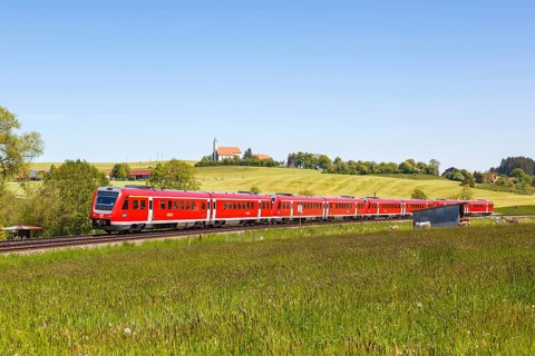 Bombardier Transportation RegioSwinger tilting technology regional train of Deutsche Bahn DB with church St. Alban in Allgaeu Bavaria in Aitrang