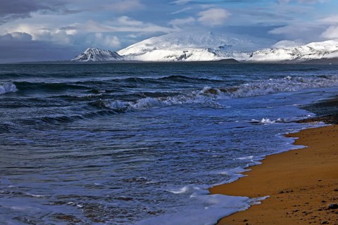 Beach with surf and the volcano and glacier Snaefellsjoekull