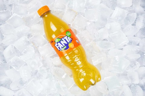 Fanta Orange lemonade soft drink beverage in a plastic bottle on ice cube ice cubes in Germany