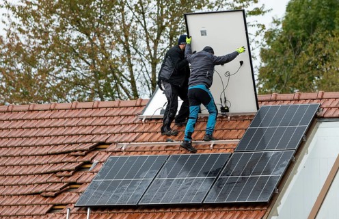 Technicians assembling a photovoltaic system on the roof of a residential building in Markt Swabia