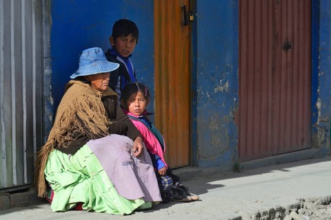 Sitting indigenous woman with two grandchildren