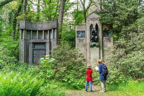 Woman and girl looking at historical gravestones