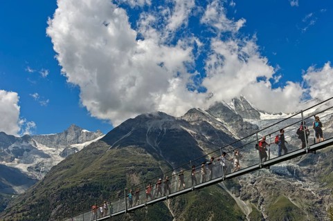 Hikers crossing the Charles Kuonen suspension bridge