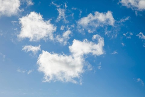 Feather and fleecy clouds adorn the blue sky in strong winds