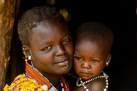 Woman with her baby sitting in a hut